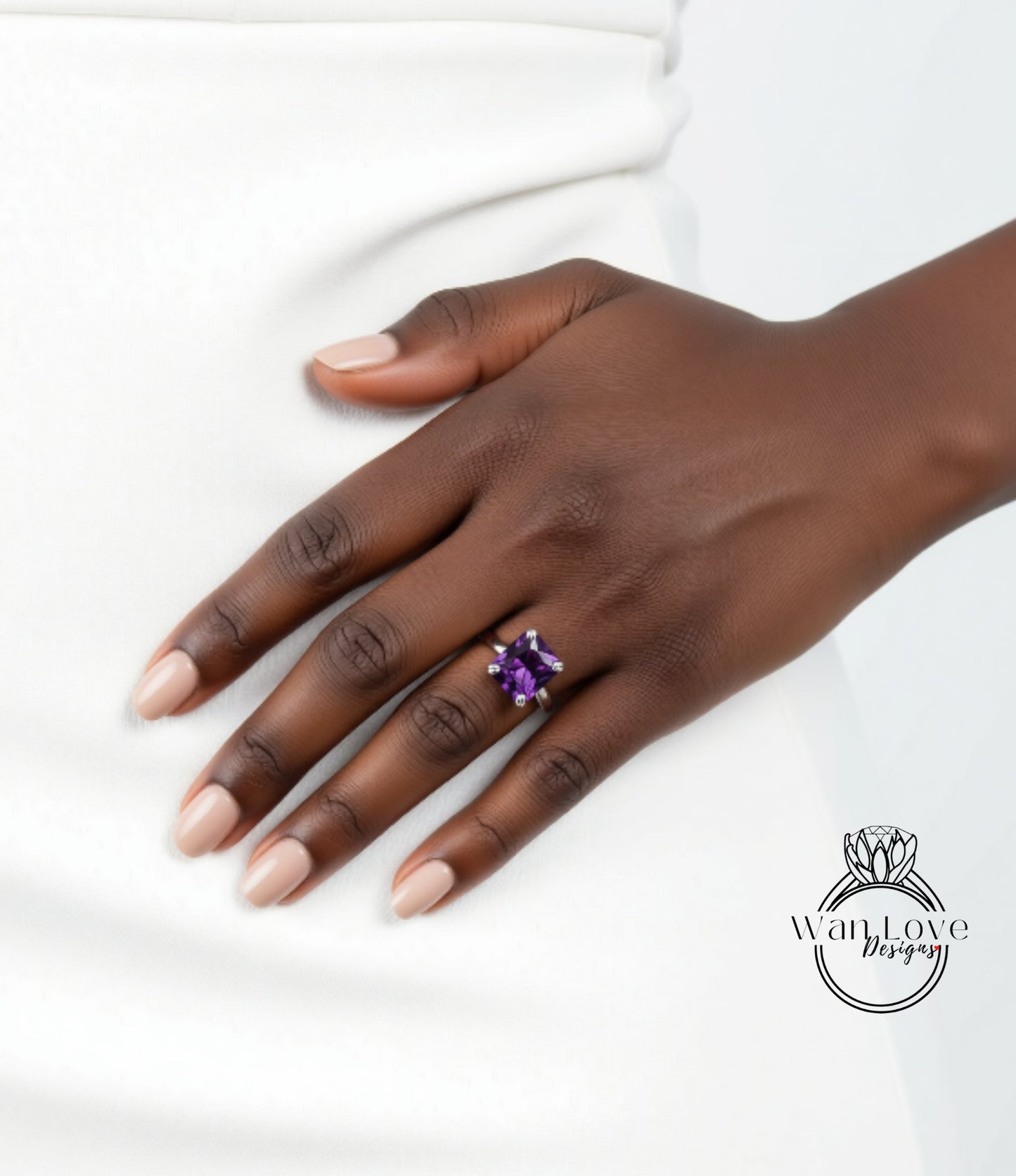 A close-up of a hand wearing a ring with a large purple gemstone.