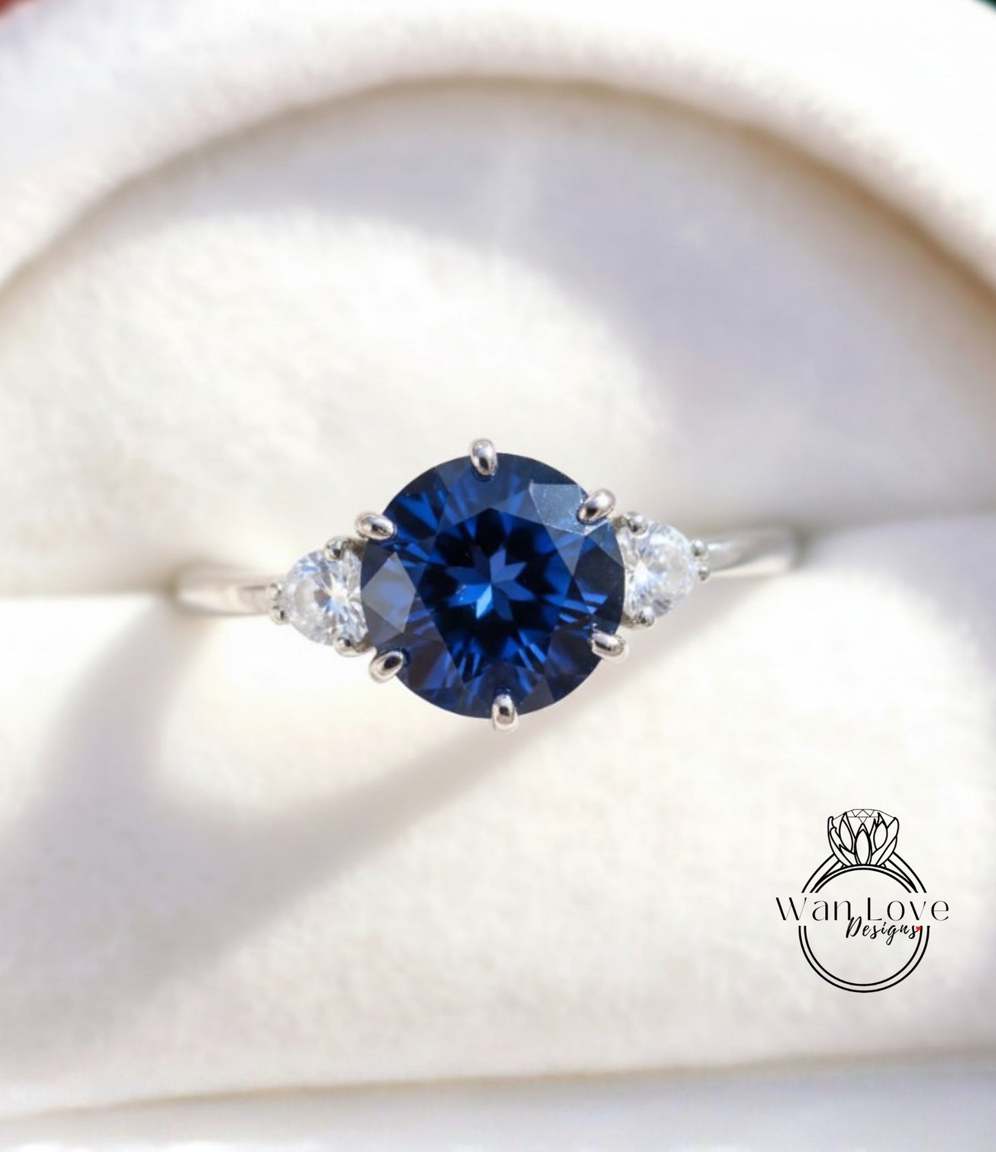 A close-up image of a silver ring with a large blue gemstone, possibly a sapphire, surrounded by smaller diamonds.