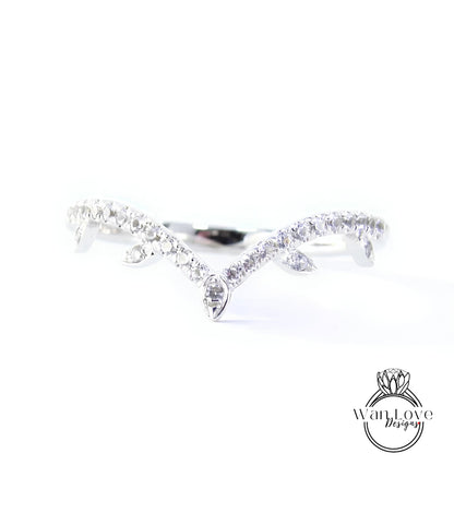 A close-up view of a diamond ring with a unique design, featuring a central diamond surrounded by smaller diamonds arranged in a curved pattern.