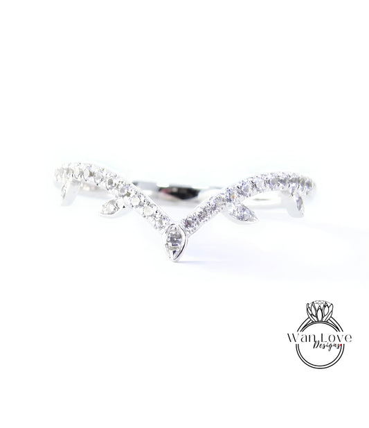 A close-up view of a diamond ring with a unique design, featuring a central diamond surrounded by smaller diamonds arranged in a curved pattern.