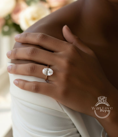 A close-up of a person's hand wearing a large, round diamond engagement ring.