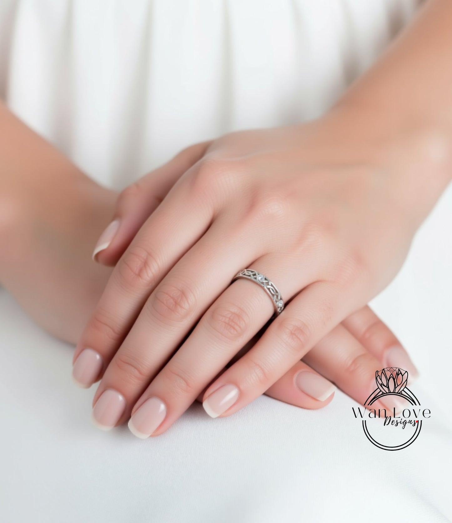 A close-up image of a person's hands wearing a silver ring on the ring finger.
