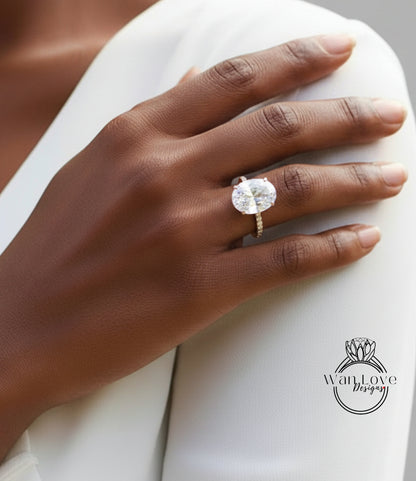 A close-up of a person's hand wearing a large, sparkling diamond engagement ring.