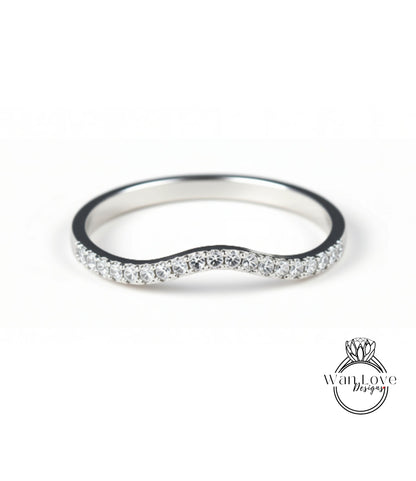 A silver ring with a wavy band and small diamonds set in it.