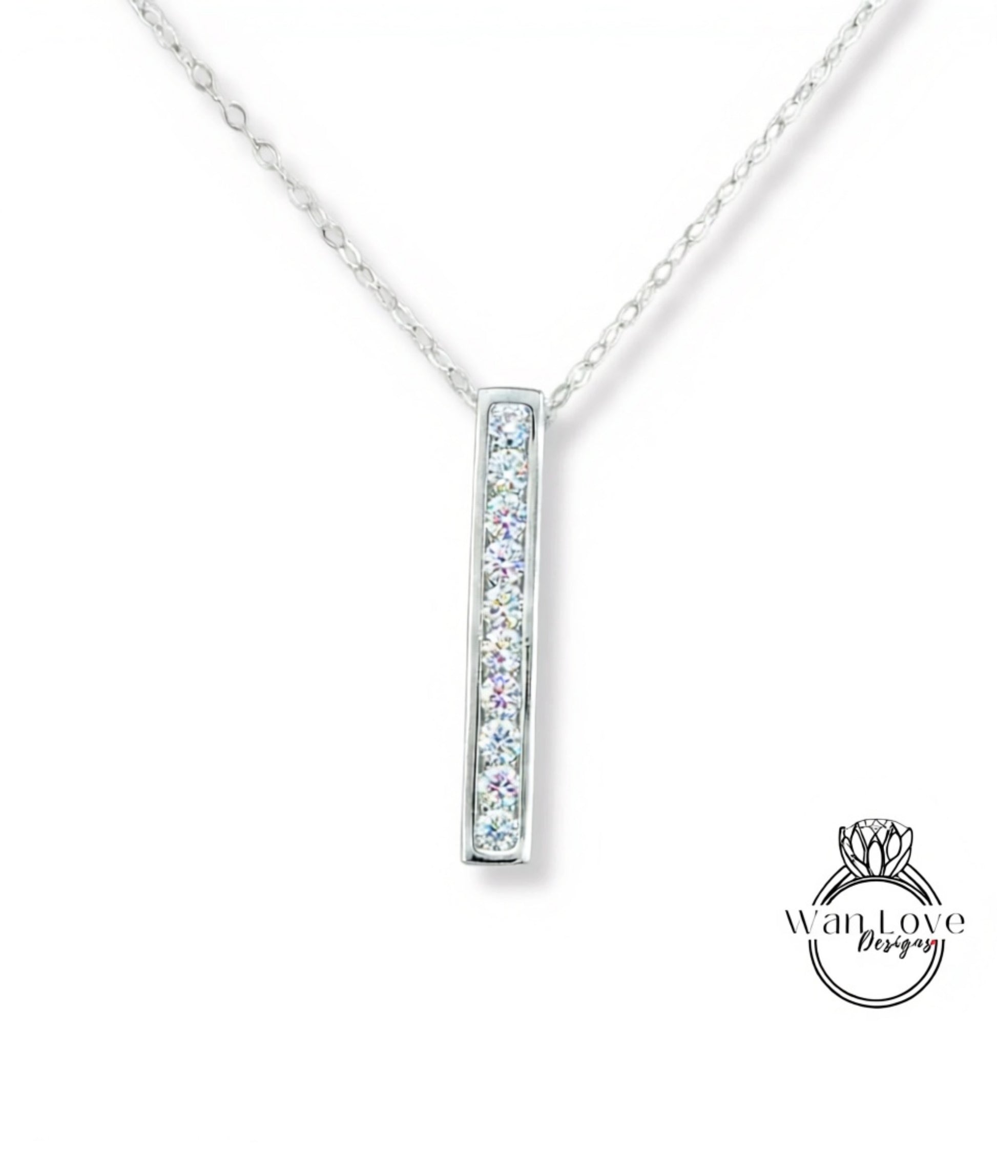 A silver necklace with a rectangular pendant featuring a row of clear gemstones.