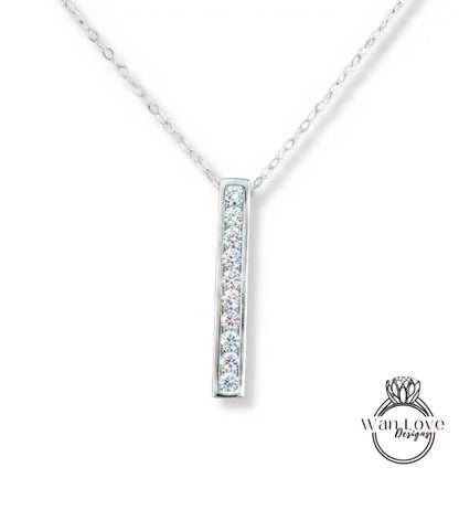 A silver necklace with a rectangular pendant featuring a row of clear gemstones.