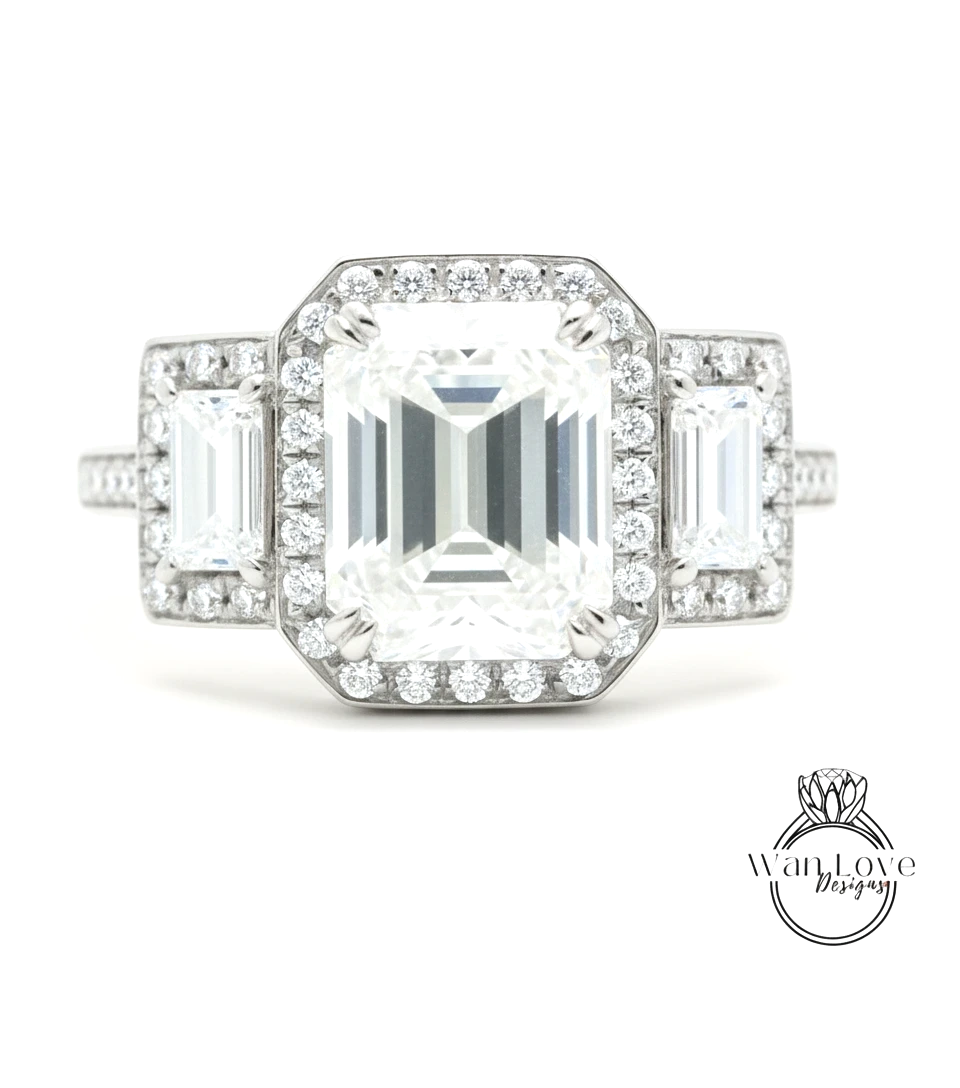 A close-up of a diamond engagement ring with a large central diamond surrounded by smaller diamonds on either side.