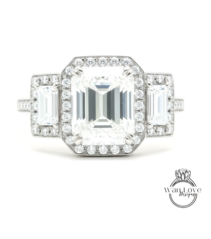 A close-up of a diamond engagement ring with a large central diamond surrounded by smaller diamonds on either side.