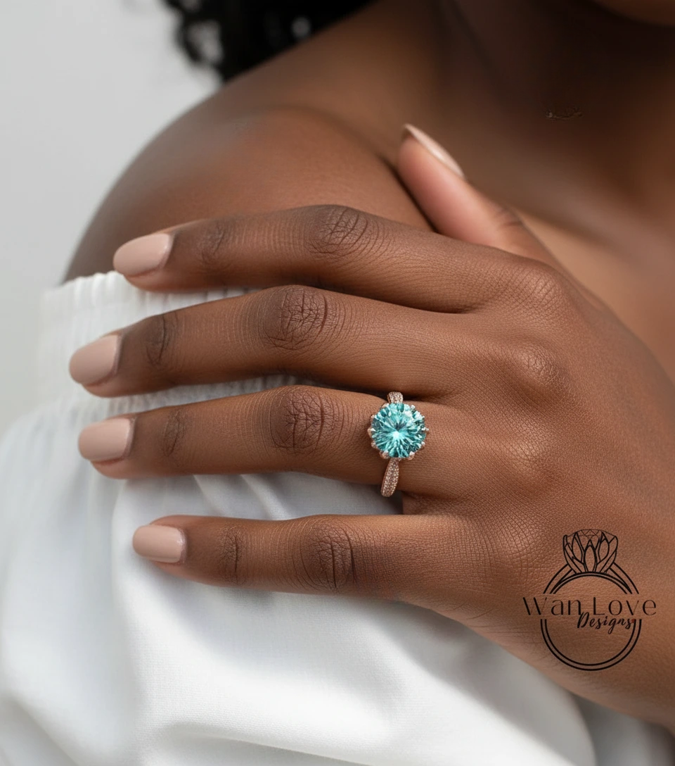 A close-up of a person's hand wearing a ring with a large blue gemstone.