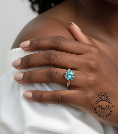 A close-up of a person's hand wearing a ring with a large blue gemstone.