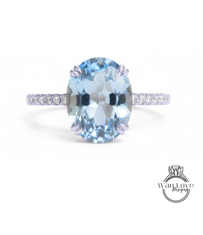 A beautiful blue gemstone ring with a band of smaller diamonds.