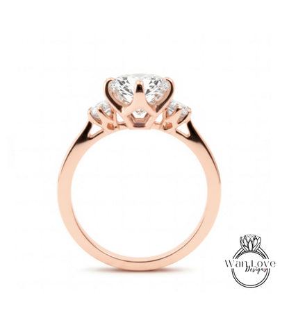 A rose gold engagement ring with a large central diamond and smaller diamonds on either side.