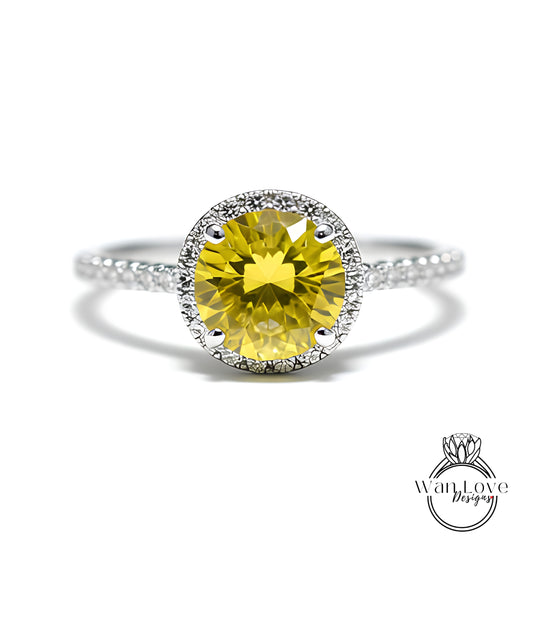 A yellow diamond ring with a halo of smaller diamonds around the center stone.