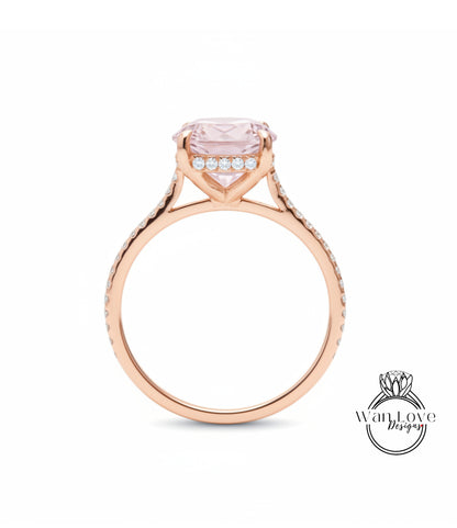 A rose gold engagement ring with a large pink gemstone set in the center, surrounded by smaller diamonds.