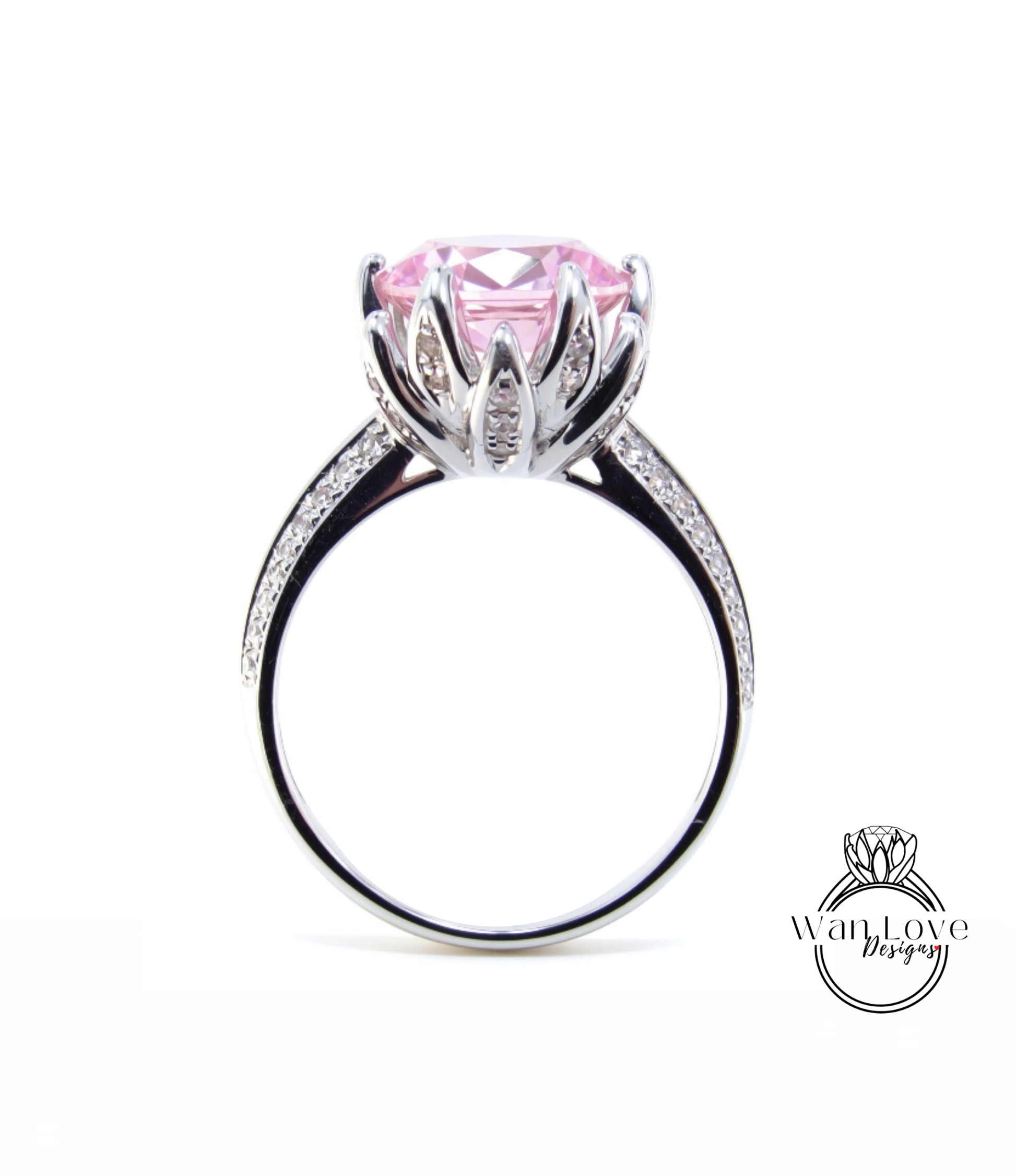 A silver ring with a large pink gemstone, likely a diamond, set in a decorative flower-like design.