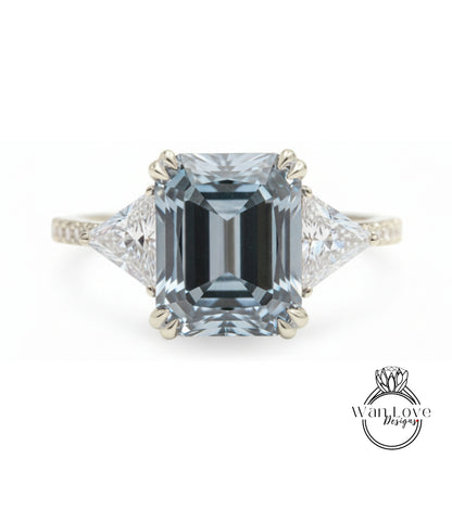 A stunning engagement ring featuring a large, rectangular-shaped blue gemstone set in a silver band, with two smaller diamonds on either side.