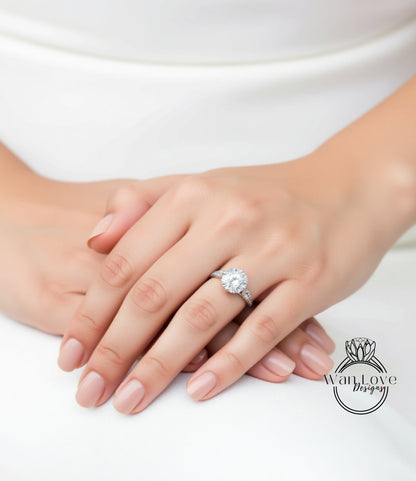 A close-up of a person's hand wearing a diamond engagement ring.