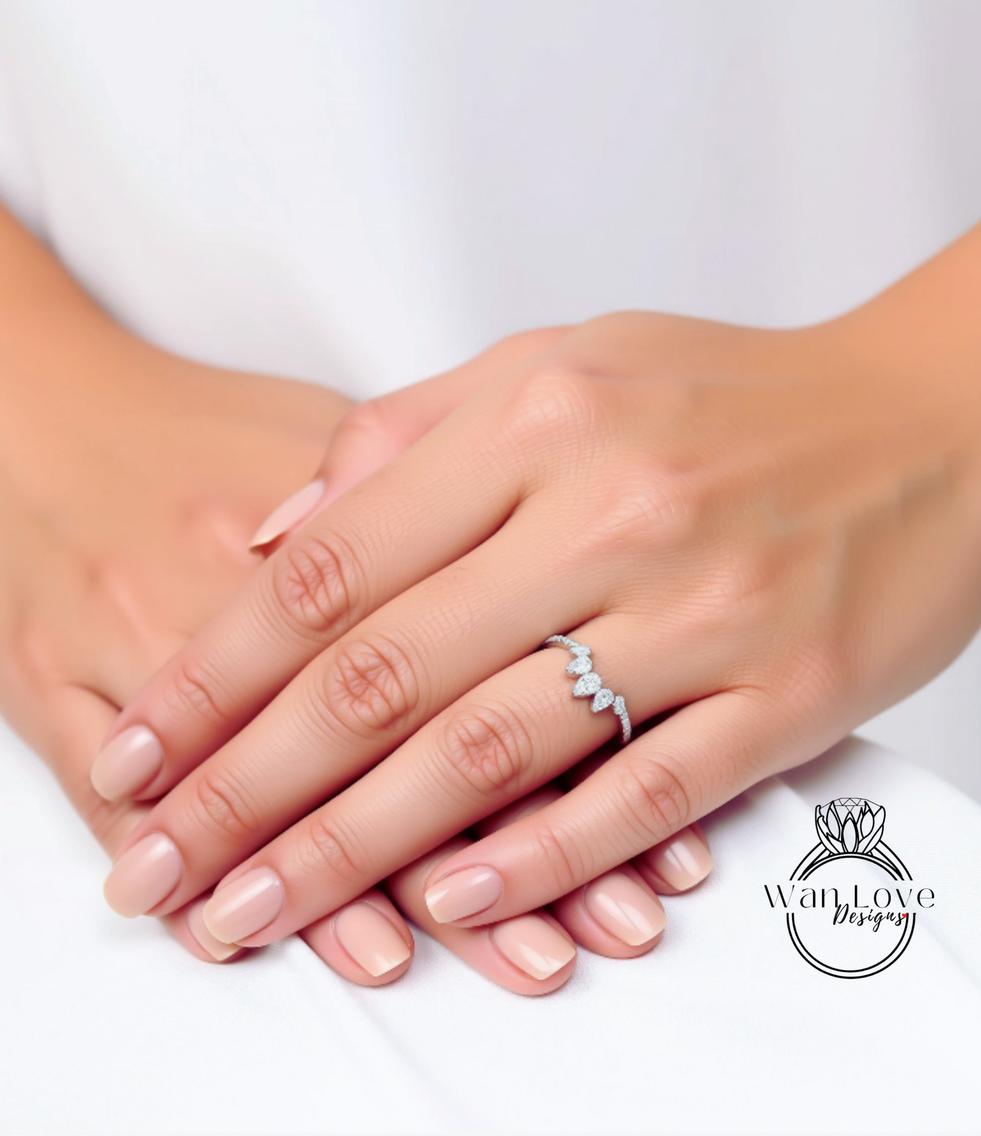 A close-up image of a person's hands with a diamond ring on the ring finger.
