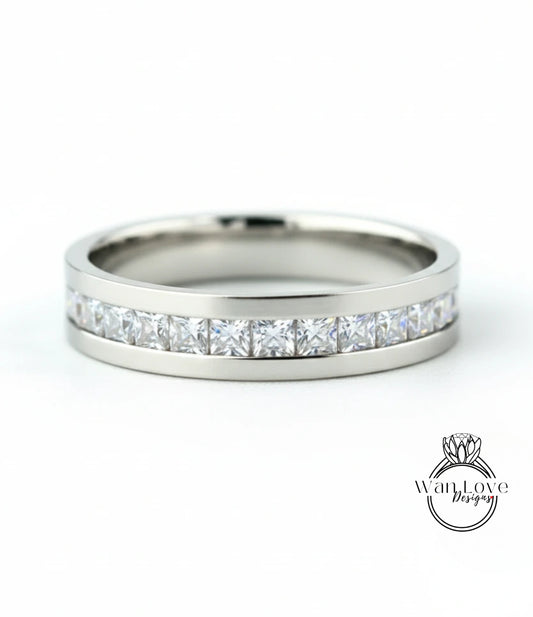 A silver band ring with a row of clear diamonds set in it.
