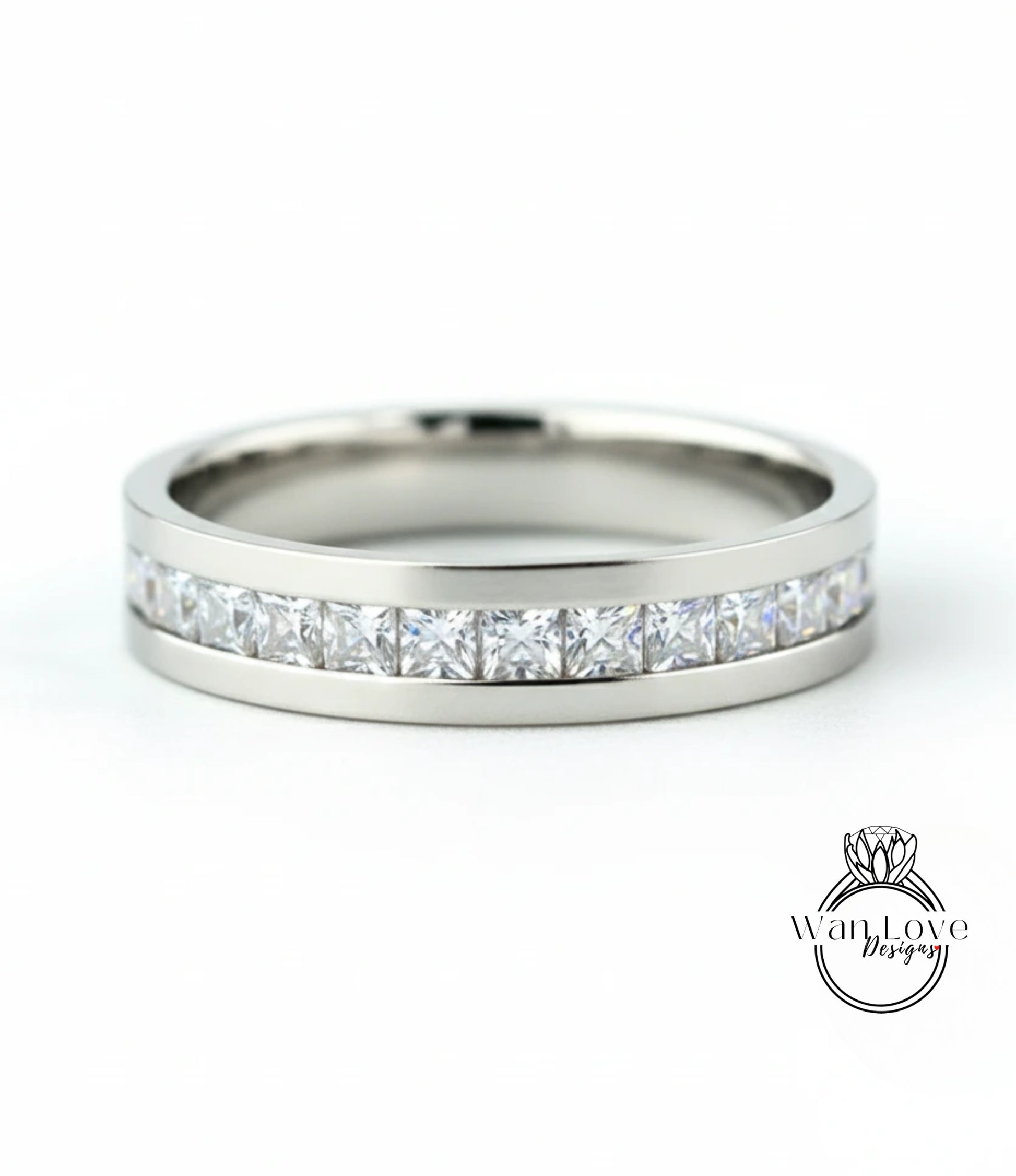 A silver band ring with a row of clear diamonds set in it.