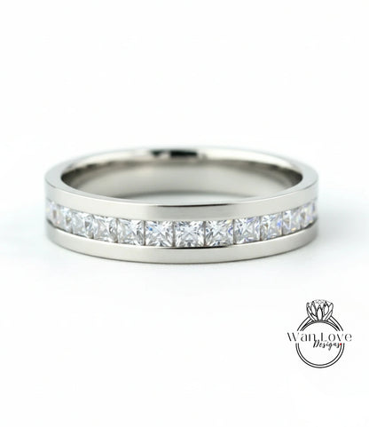 A silver band ring with a row of clear diamonds set in it.