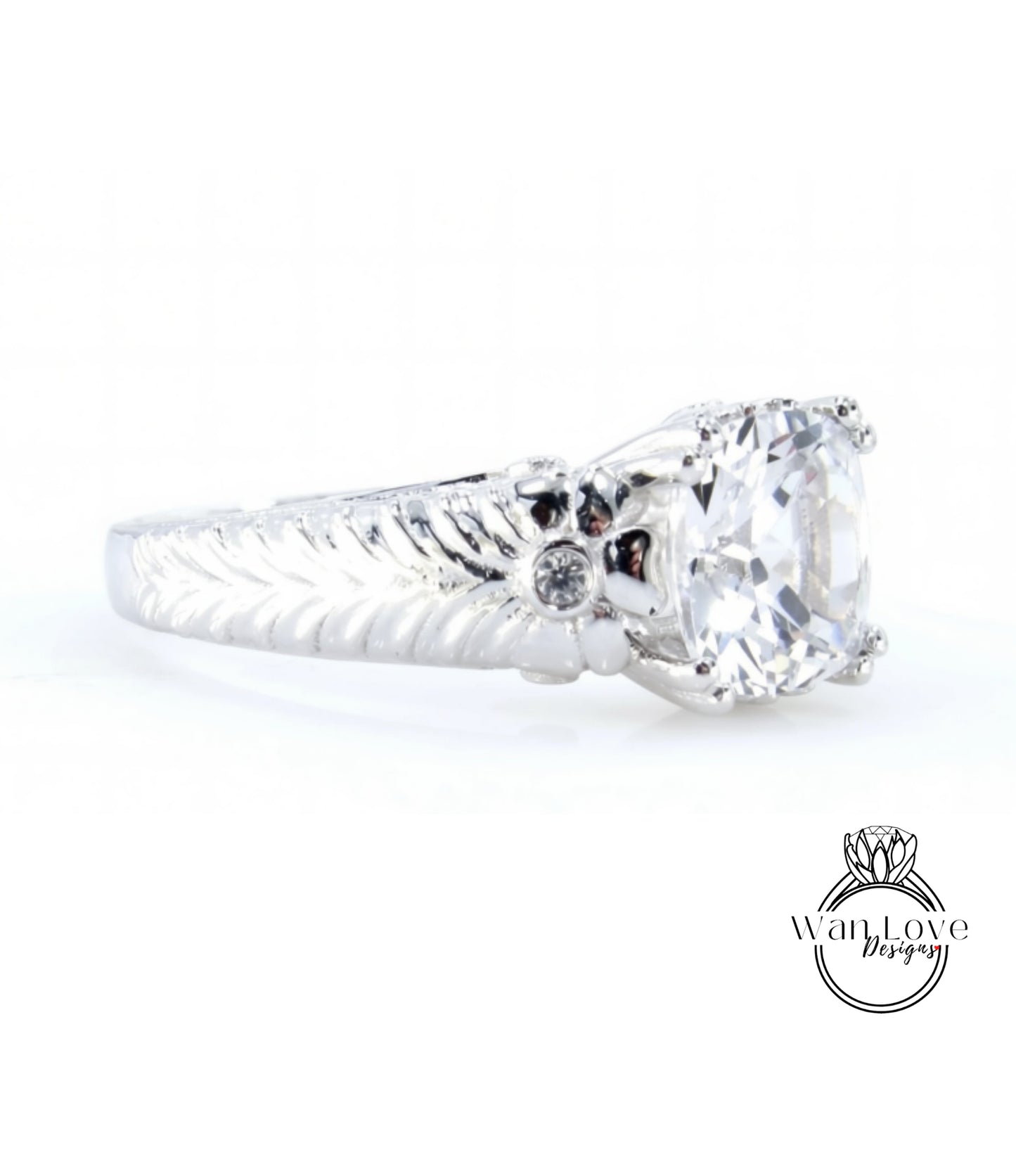 A close-up view of a silver ring with a large central diamond and a decorative leaf-like design on the band.