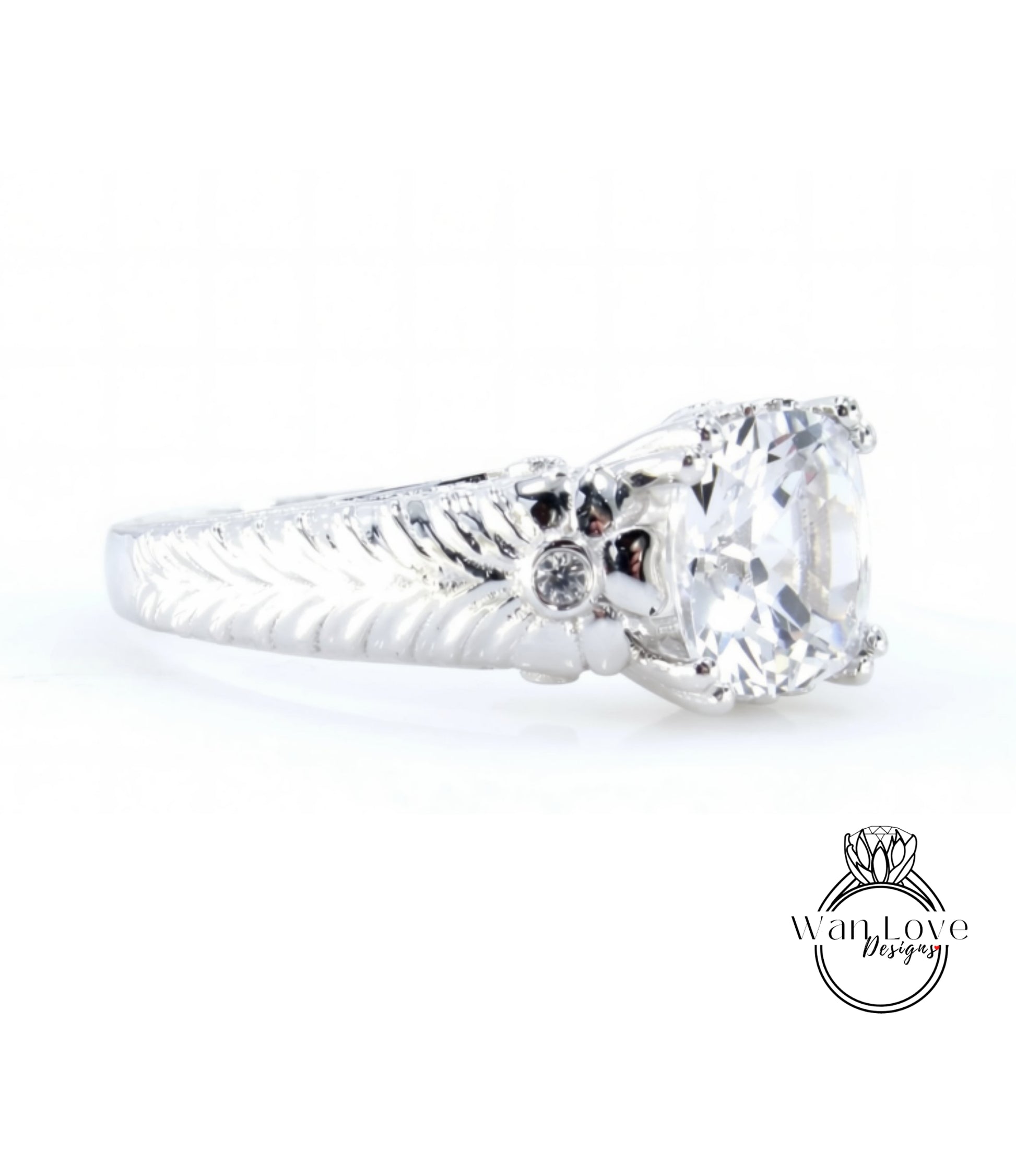 A close-up view of a silver ring with a large central diamond and a decorative leaf-like design on the band.