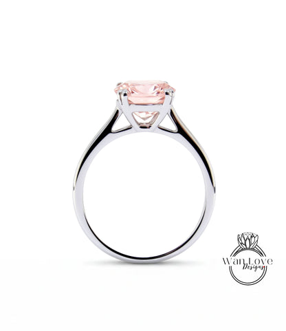 A silver engagement ring with a large pink gemstone set in the center.