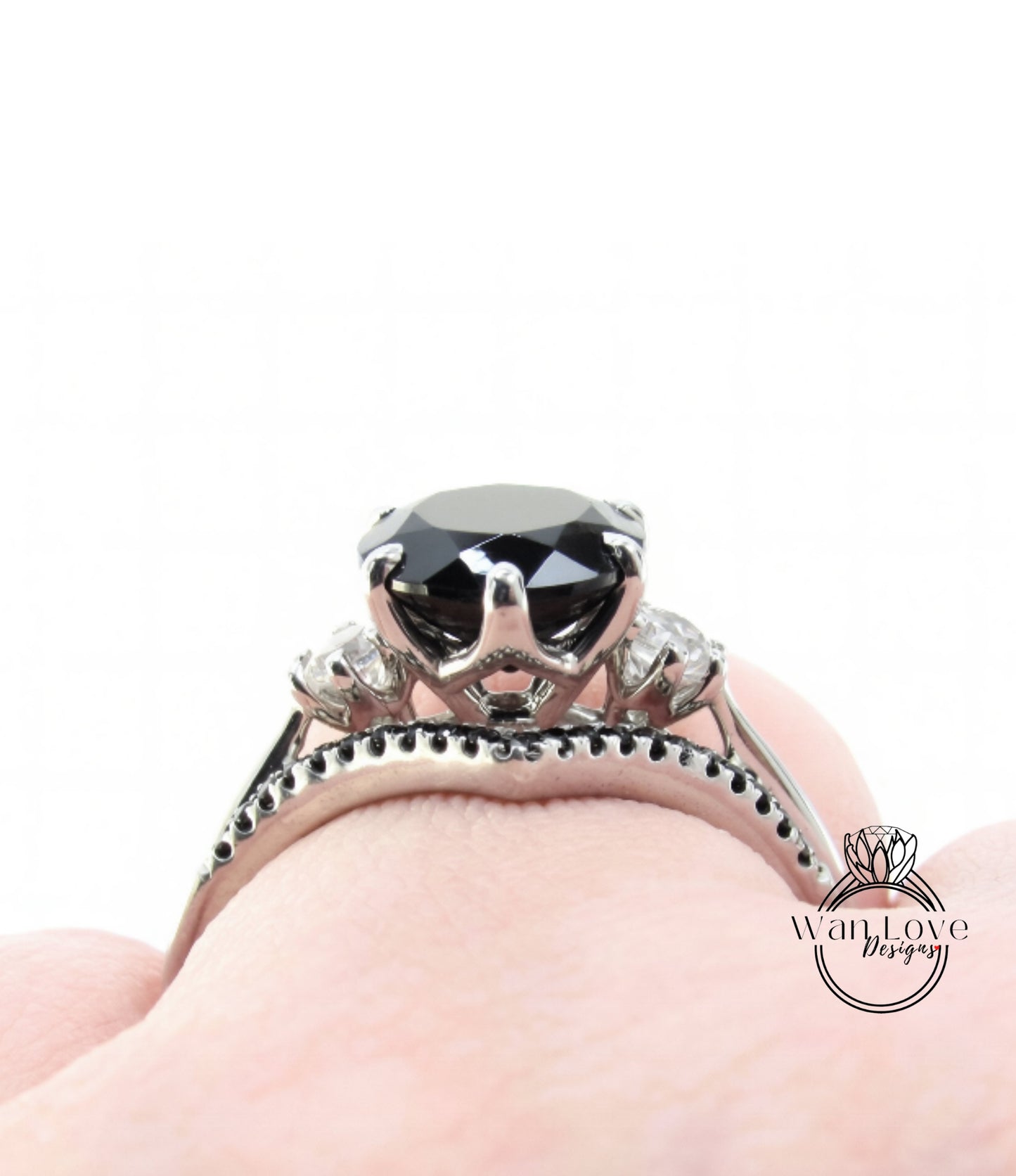 A close-up view of a silver ring with a large black gemstone, possibly a diamond, set in a decorative band.