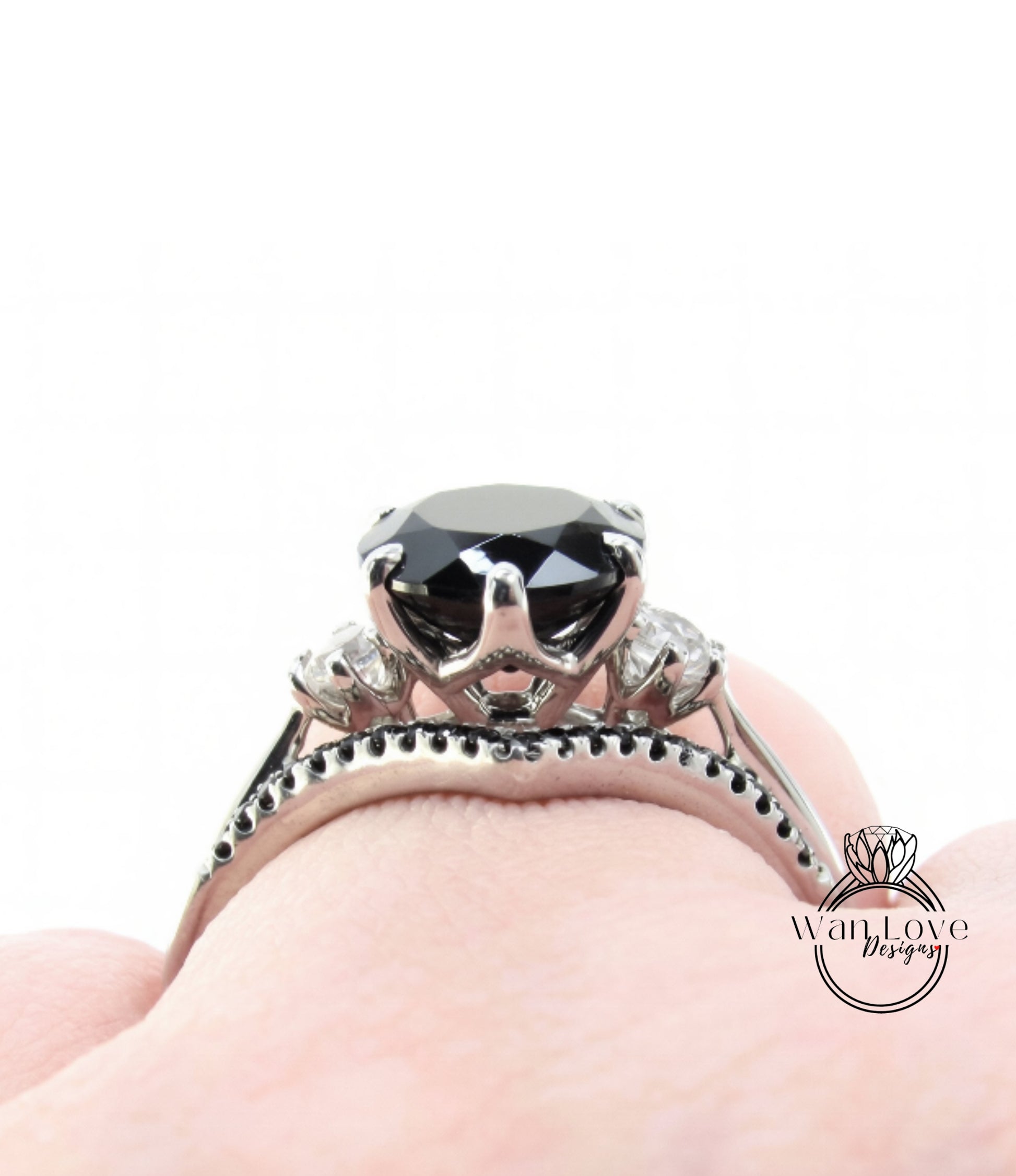 A close-up view of a silver ring with a large black gemstone, possibly a diamond, set in a decorative band.