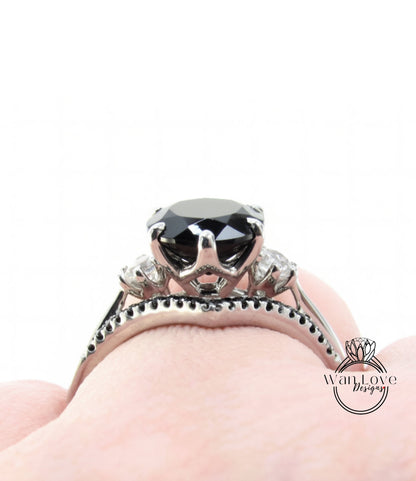 A close-up view of a silver ring with a large black gemstone, possibly a diamond, set in a decorative band.