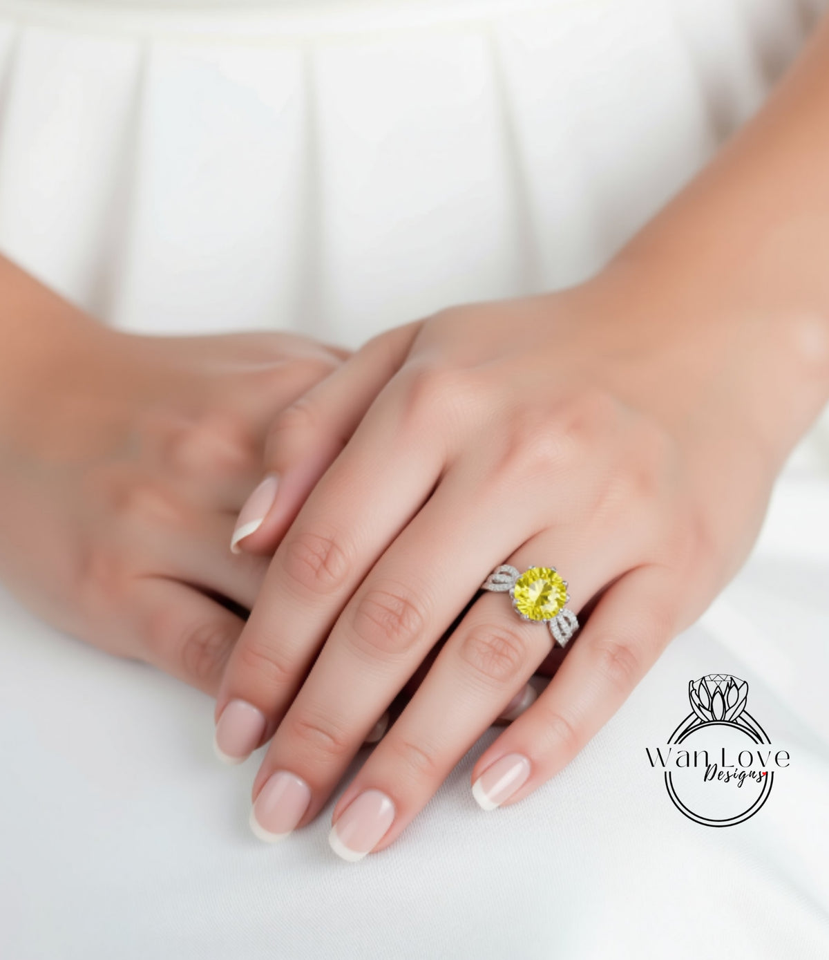 A close-up of a person's hand wearing a yellow diamond ring on the ring finger.