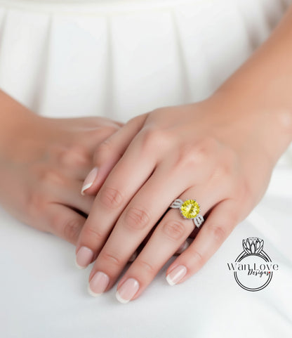 A close-up of a person's hand wearing a yellow diamond ring on the ring finger.