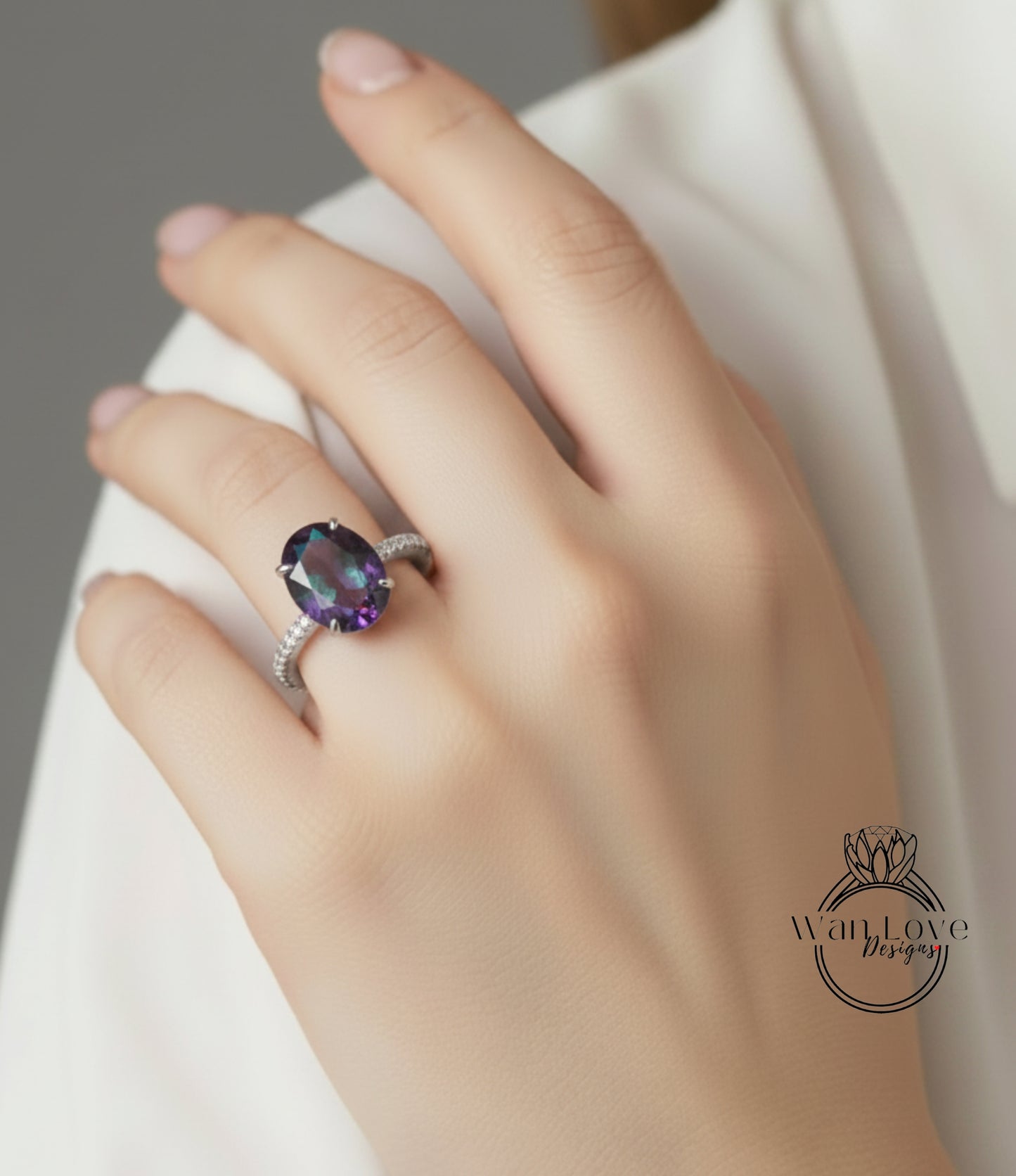 A close-up of a hand wearing a ring with a large purple gemstone.