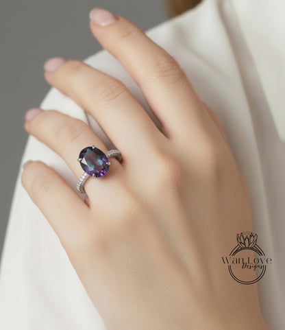 A close-up of a hand wearing a ring with a large purple gemstone.