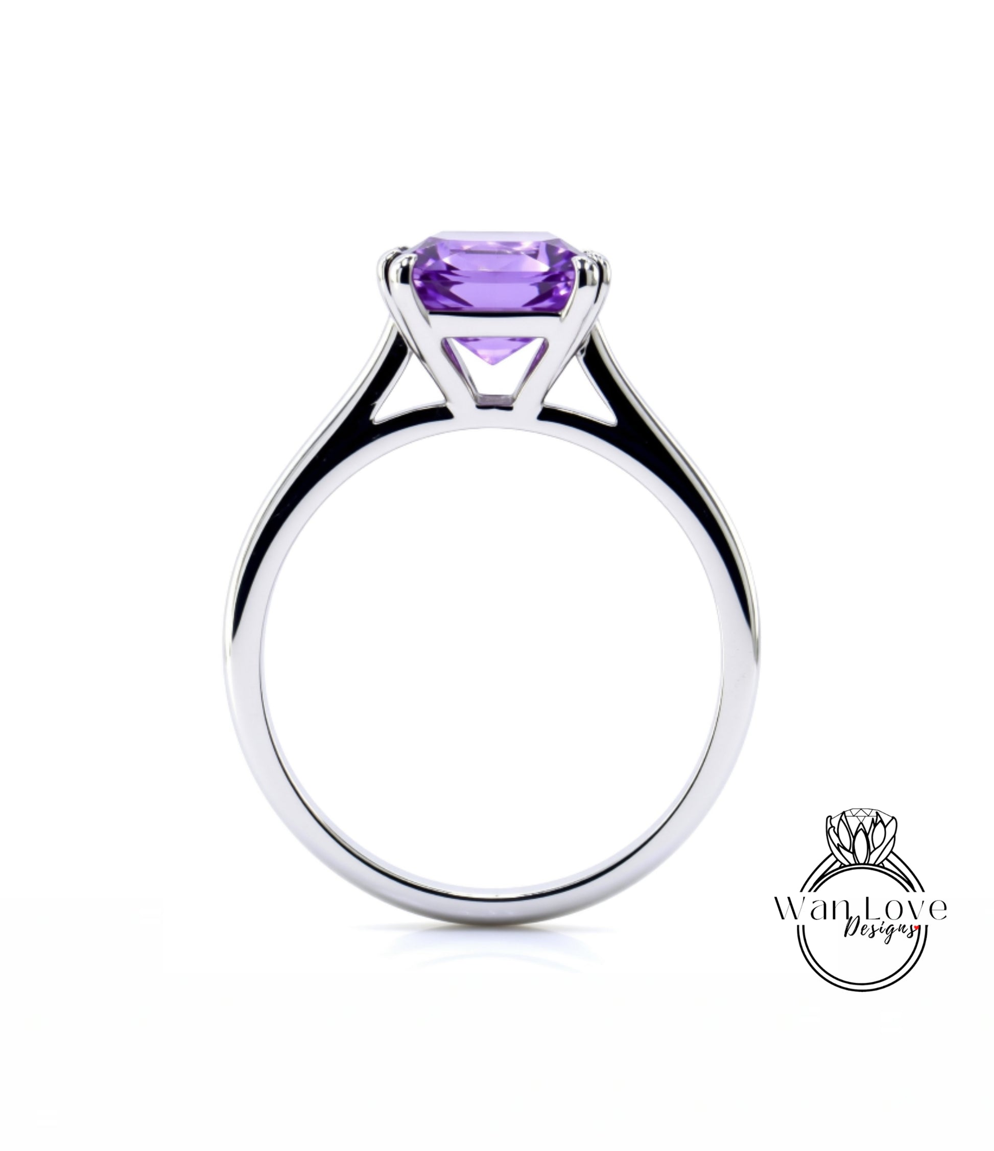 A silver ring with a large purple gemstone, likely an amethyst, set in the center.