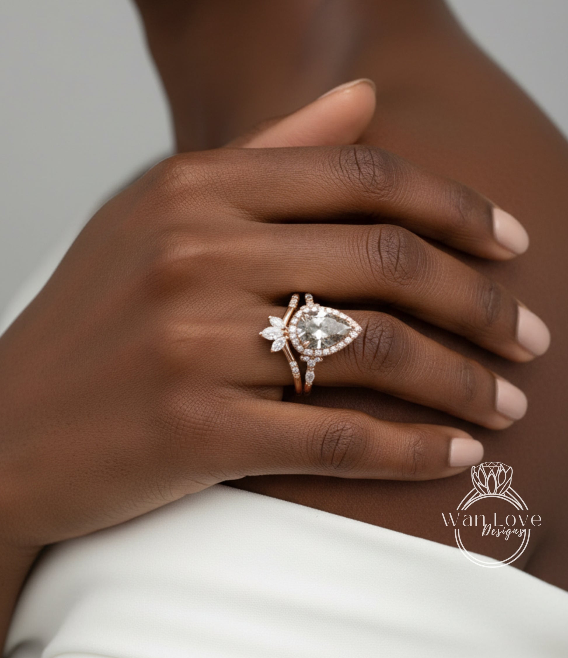 A close-up of a person's hand wearing a diamond engagement ring with a large central diamond and smaller diamonds around it.