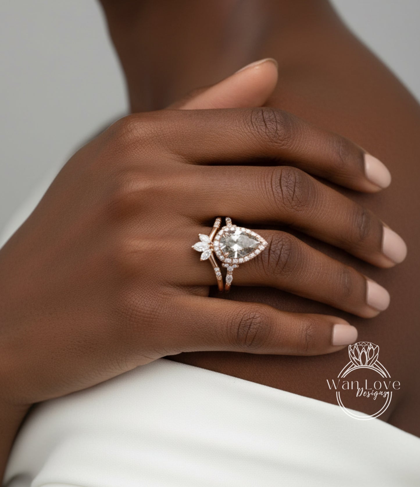 A close-up of a person's hand wearing a diamond engagement ring with a large central diamond and smaller diamonds around it.