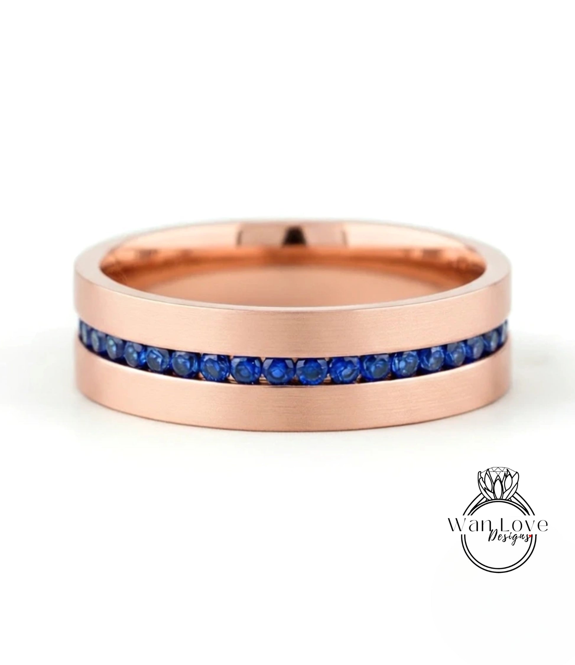 A rose gold ring with a row of blue sapphires embedded in the band.