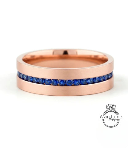 A rose gold ring with a row of blue sapphires embedded in the band.