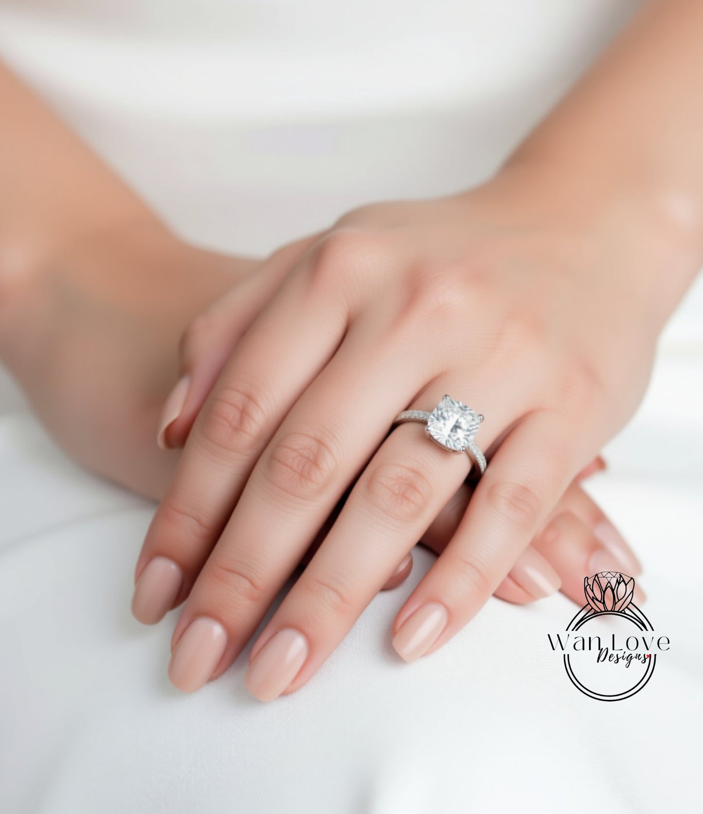 A close-up of a person's hand wearing a diamond engagement ring.