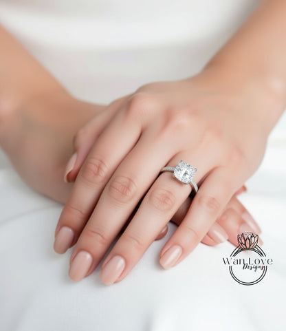 A close-up of a person's hand wearing a diamond engagement ring.
