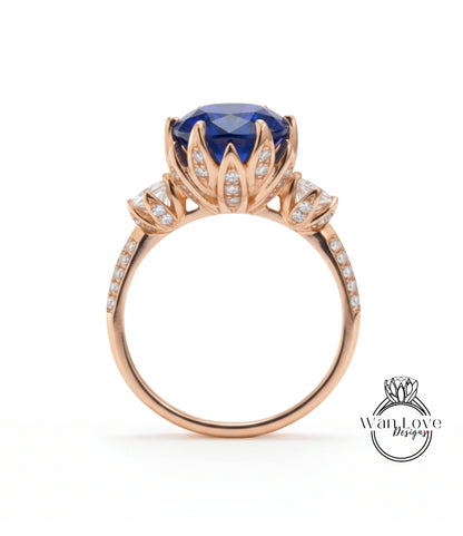 A gold ring with a large blue gemstone, likely a sapphire, at the center. The ring has a delicate floral design around the gemstone and is adorned with small diamonds.