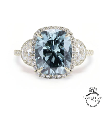 A stunning engagement ring with a large, blue gemstone set in a halo of smaller diamonds, surrounded by a delicate band of white diamonds.