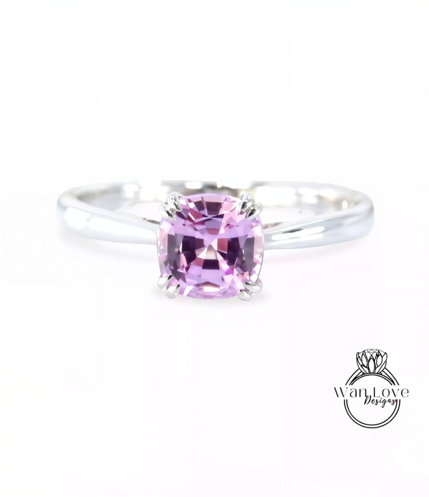 A silver ring with a large, square-cut pink gemstone, which appears to be a sapphire.