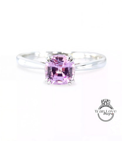 A silver ring with a large, square-cut pink gemstone, which appears to be a sapphire.