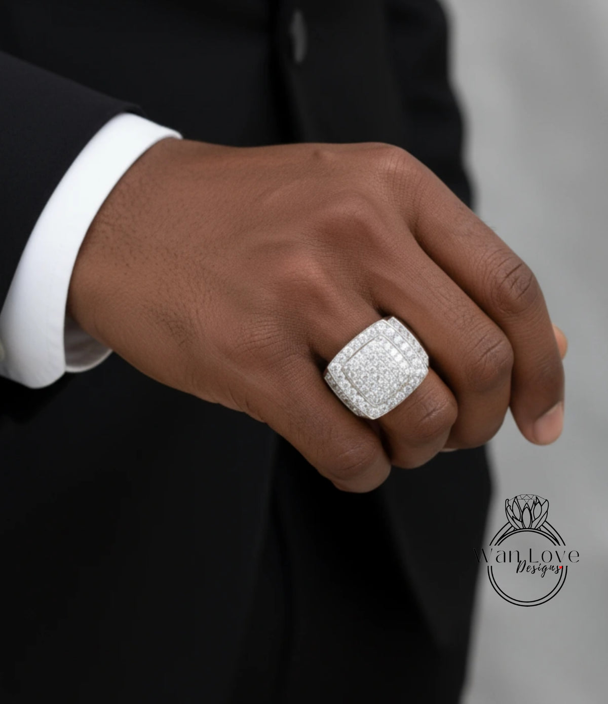 A close-up of a person's hand wearing a large, diamond-encrusted ring.