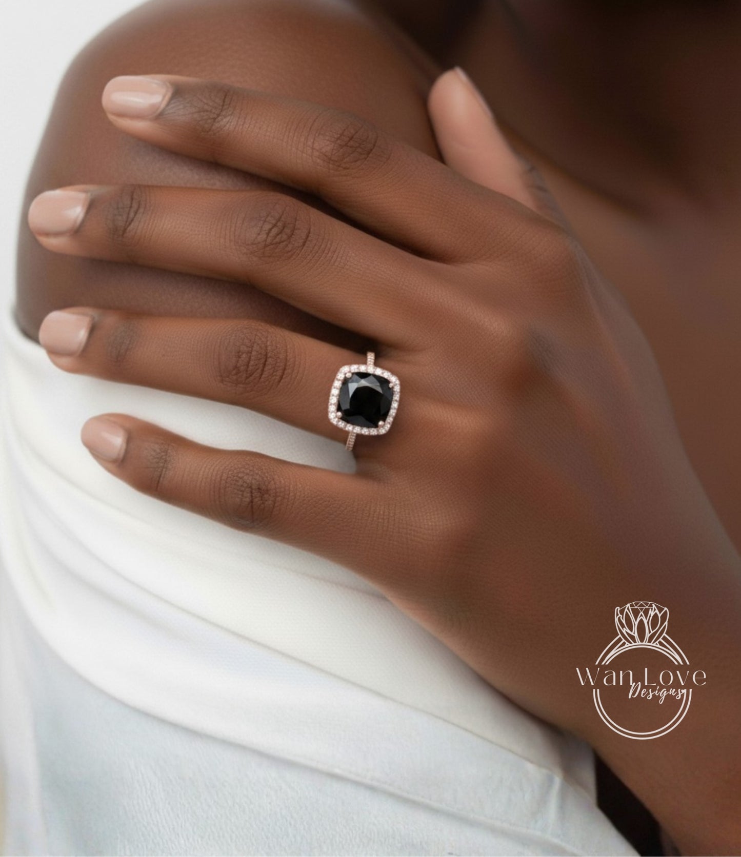 A close-up of a person's hand wearing a ring with a large black gemstone, likely a diamond, set in a gold ring band.