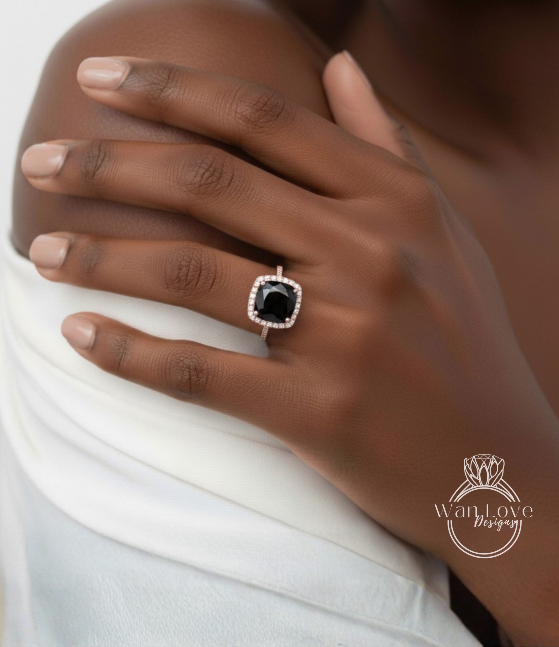 A close-up of a person's hand wearing a ring with a large black gemstone, likely a diamond, set in a gold ring band.
