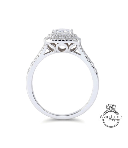 A silver engagement ring with a large central diamond surrounded by smaller diamonds, set in a halo of smaller diamonds.